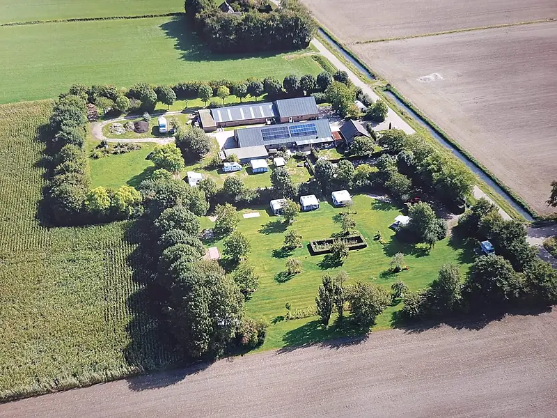 Luchtfoto van minicamping ’t Mostoch: het boerenerf met het kampeerveld tussen de akkers