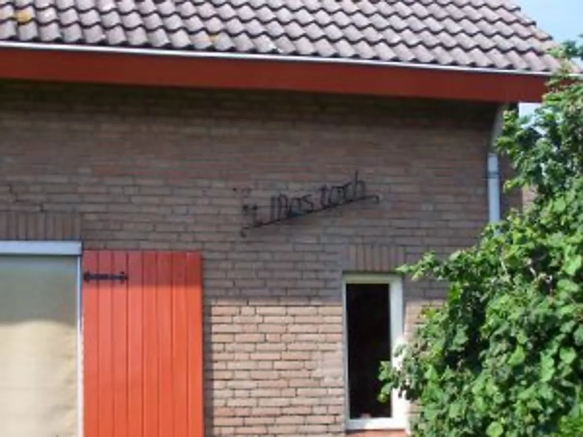 Schuur met rode deur op het erf van minicamping ’t Mostoch